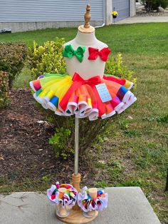 a dress made out of fabric on top of a wooden stand in front of a house