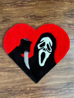 a heart shaped rug with a black and white face holding a knife