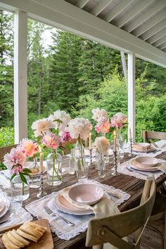 the table is set with flowers and plates