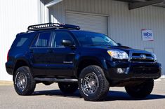 a black suv parked in front of a building