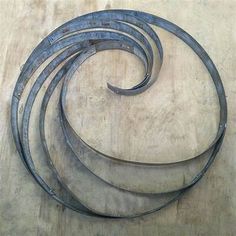 four metal spirals sitting on top of a wooden table