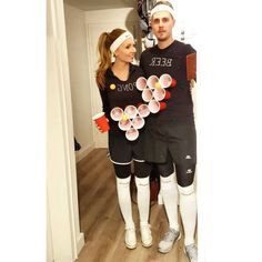 a man and woman standing next to each other in front of a mirror wearing soccer gear