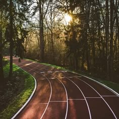 the sun shines through the trees on a running track