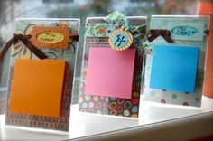 three small cards are sitting on a window sill, each with a notepad attached to it