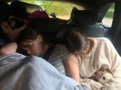 two girls sleeping in the back of a car