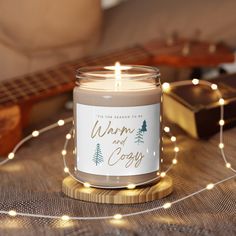 a candle that is sitting on a table next to some string lights and a guitar