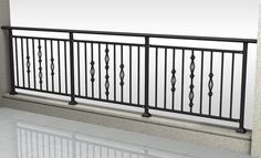 an empty room with white tile flooring and black iron railings on the balcony