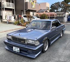 a blue car is parked in front of some houses