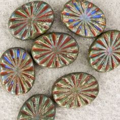 five glass buttons with different designs on them sitting on the ground next to each other