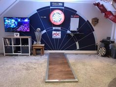 a room with two televisions and darts on the wall