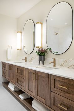 a bathroom with double sinks and two mirrors on the wall next to eachother