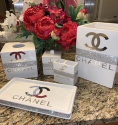 a bouquet of flowers sitting on top of a counter next to boxes with chanel logos