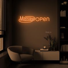 a neon sign that reads massage open on the wall above a chair in a dark room