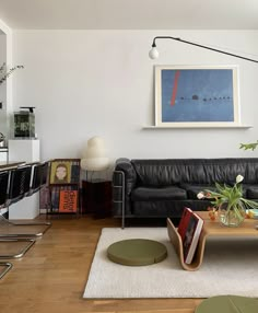 a living room filled with furniture and a painting on the wall