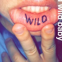 a close up of a person's tongue with the word wild written on it