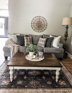 a living room with a couch, coffee table and rug on the floor in front of it