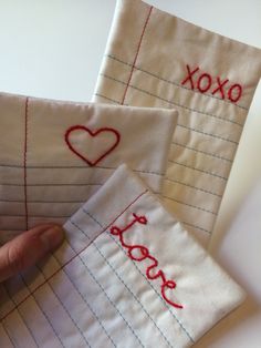 someone is stitching out the word love on two pieces of fabric