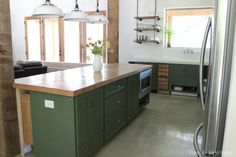 a kitchen with green cabinets and an island