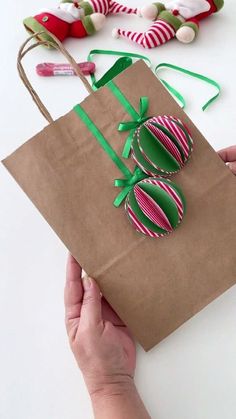 someone is holding a brown paper bag with green and pink decorations on it