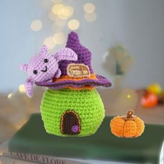 a crocheted witch's hat sits on top of a book