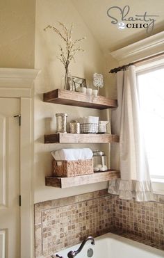 three wooden shelves in the bathroom with towels and other items on top of each shelf