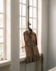 a shirt hanging on a clothes rack in front of a window