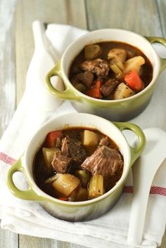 two bowls filled with stew on top of a table