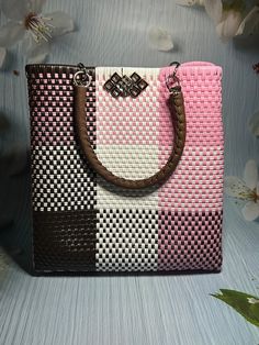 a pink, white and brown purse sitting on top of a table