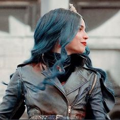 a woman with blue hair wearing a leather jacket