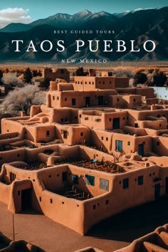 the taos pueblo with mountains in the background