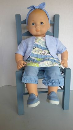 a baby doll sitting in a blue chair