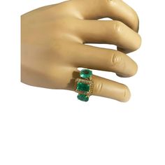 This stylish Art Deco Style  18K yellow gold emerald and diamond 3 stone ring features a 4 prong mounting with a 4.5mm shank and open gallery. Its finger size is 7.5, and is centered around an emerald cut emerald of fair quality, measuring 9.15 by 5.38 by 4.75 mm and totaling 1.61 carats.  Accenting the emerald are two 14 full cut 1.7 mm 02 point bead set diamonds of I/SI quality, and two fair grade oval emeralds at 9.1 by 6.9 by 2.65 mm and 9.4 by 6.65 by 2.6 mm, totaling 93 and 92 points respe Art Deco Multi-stone Emerald Ring For Anniversary, Luxury Heirloom Three-stone Emerald Ring, Antique Gold Emerald Ring With Multi-stone, Luxury Heirloom Multi-stone Emerald Ring, Art Deco Green Emerald Multi-stone Ring, Diamond Three Stone Ring, 3 Stone Ring, Open Gallery, Stylish Art