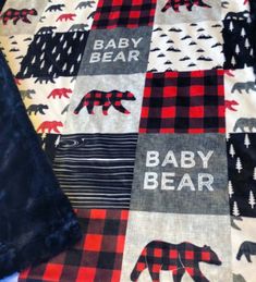 the baby bear quilt is laying on top of the table cloth, and it's black and red