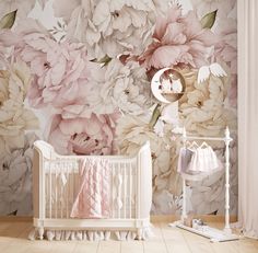 a baby crib in front of a floral wallpaper