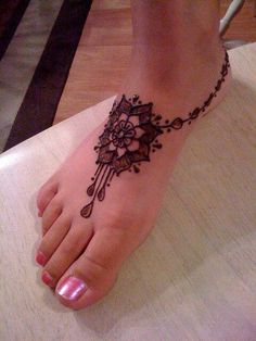 a woman's foot with a henna tattoo on it