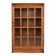 an oak bookcase with glass doors on the front and bottom, against a white background