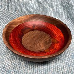 a wooden bowl sitting on top of a blue cloth