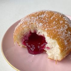 a jelly filled doughnut on a pink plate