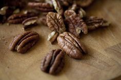 some pecans are on a wooden cutting board