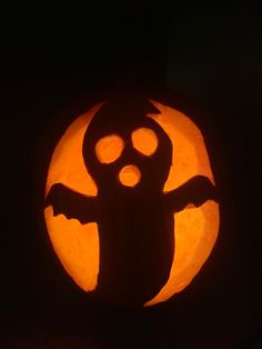 a carved pumpkin with a silhouette of a ghost