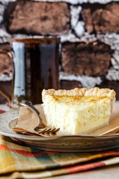 a piece of pie sitting on top of a plate next to a cup of coffee