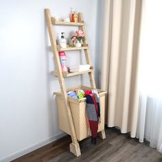 a wooden ladder leaning up against a wall next to a basket with items in it