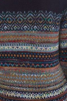 the back of a woman's sweater with multicolored knits on it