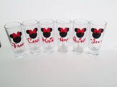 six mickey mouse glasses with red bows on them are lined up against a white background