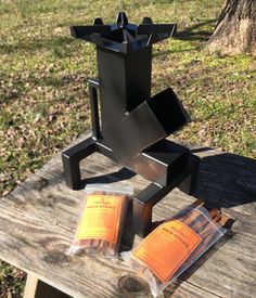 a sculpture made out of metal sitting on top of a wooden table in the grass