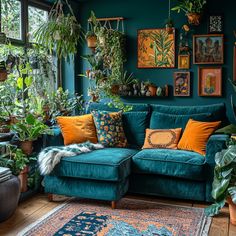 a living room filled with lots of plants and potted plants on the wall next to a blue couch