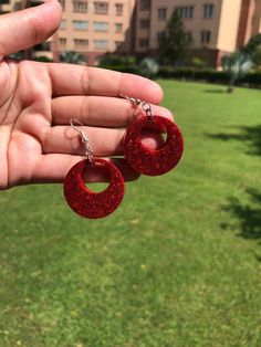 Add a pop of color to your outfit with these bold red glitter resin hoop earrings. Handcrafted with care, each pair shines with a unique sparkle, perfect for those who love statement jewelry. These lightweight earrings are comfortable for all-day wear and make an eye-catching addition to any accessory collection. Looking for something custom? We offer personalized options to match your style. Contact us for custom colors or designs to make these hoops uniquely yours! All of my jewelry is handcra Trendy Red Circular Jewelry, Trendy Red Resin Earrings, Plastic Round Jewelry For Parties, Round Plastic Party Jewelry, Red Small Hoop Earrings For Party, Small Red Hoop Earrings For Party, Plastic Hoop Jewelry Gift, Red Plastic Party Jewelry, Red Glitter Earrings For Party