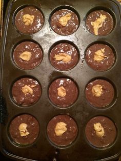 chocolate cupcakes with peanut butter frosting in a muffin tin ready to be baked