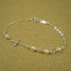 This dainty sideways cross bracelet is made with sterling silver and Swarovski pearls. The pearls are carefully hand-wired and connected together. On the clasp, there is a .925 sterling silver quality tag for a beautiful and elegant feel. Sterling silver Cable chain with spring clasp Swarovski white pearls Chain extender available here: https://goo.gl/JJlqbR Our jewelry comes carefully wrapped in a beautiful gift box with jewelry care instructions. Sterling Silver Jewelry Cleaner, Silver Cross Bracelet, Bracelet Extender, Silver Jewelry Cleaner, Christian Bracelets, Dainty Bracelet, Etsy Bridesmaid Gifts, Bridesmaid Bracelet, Chain Extenders