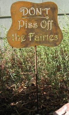 a sign that says don't piss off the fairies in front of some grass